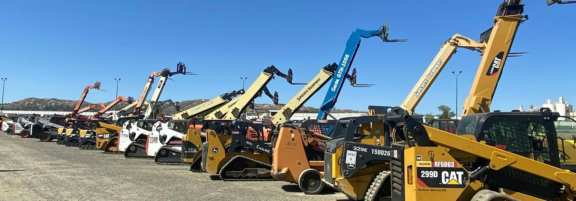 Rows of compact loaders and lifts in an equipment yard